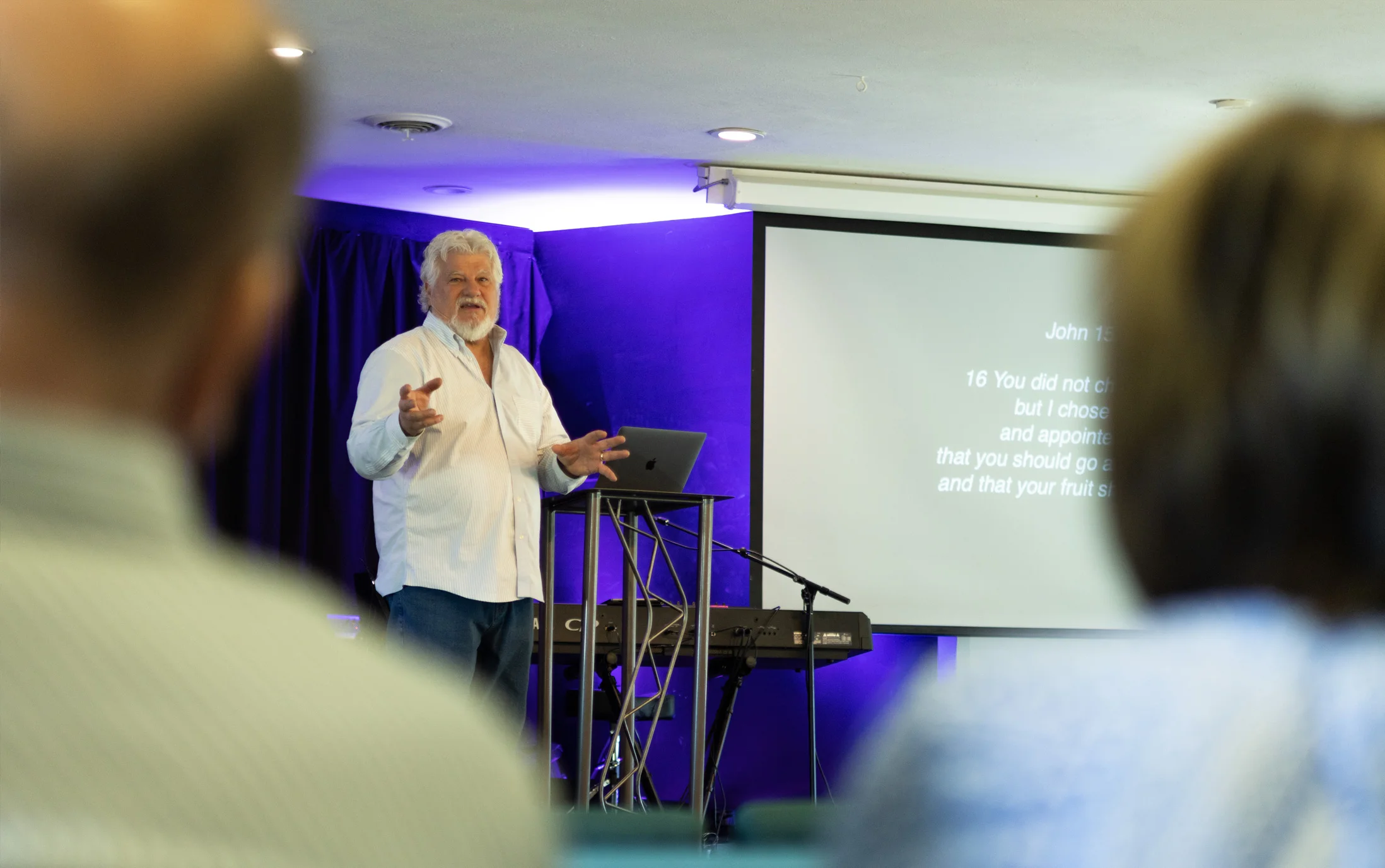 Community Christian pastor releasing gifts of the Holy Spirit over the congregation in a non-denominational worship service